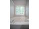 Bright, spacious bathtub with tile surround and a window at 262 Devynwood Ln, Dallas, GA 30157