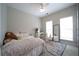 Bright bedroom with a decorative rug, two windows and a white vanity with an accompanying chair at 262 Devynwood Ln, Dallas, GA 30157