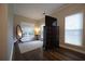 Sitting area in the bedroom with hardwood floors, a dresser, mirror, and a lamp at 262 Devynwood Ln, Dallas, GA 30157