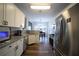 Modern kitchen with white cabinets, granite countertops, stainless steel appliances, and a dining area at 262 Devynwood Ln, Dallas, GA 30157