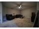 Cozy living room features neutral carpet, ceiling fan, and comfortable dark furnishings at 262 Devynwood Ln, Dallas, GA 30157