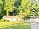 Charming single-story home with a red door, shutters, a well-manicured lawn, and a private driveway at 4363 Stonewall Tell Rd, Atlanta, GA 30349