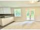 Bright room showcasing new carpet, adjacent kitchen and double doors leading to outdoor space at 4363 Stonewall Tell Rd, Atlanta, GA 30349
