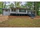 Rear exterior view of home showcasing deck and landscaped backyard with mature trees at 1329 Hidden Hills Pkwy, Stone Mountain, GA 30088