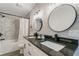 Inviting bathroom with double sinks, granite counters, tub with shower, and decorative round mirrors at 1329 Hidden Hills Pkwy, Stone Mountain, GA 30088