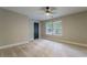 This bedroom has neutral walls, new carpet, a ceiling fan, and two windows for natural light at 1329 Hidden Hills Pkwy, Stone Mountain, GA 30088