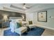 Comfortable bedroom featuring a tray ceiling, stylish decor, and a cozy seating area on a blue rug at 1329 Hidden Hills Pkwy, Stone Mountain, GA 30088