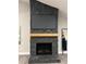 Stone fireplace with a wooden mantle and mounted television set against a light gray wall at 1329 Hidden Hills Pkwy, Stone Mountain, GA 30088