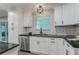 Kitchen with white cabinets, stainless appliances, black hardware, countertops, and tiled backsplash at 1329 Hidden Hills Pkwy, Stone Mountain, GA 30088