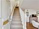 Inviting foyer with a carpeted staircase and wood floors that leads into a beautifully decorated living area at 162 Lablanc Nw Way, Atlanta, GA 30327