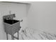 Bathroom under construction with stainless steel utility sink and bright marble flooring at 2764 Midway Rd, Decatur, GA 30030