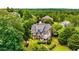 Aerial view of a home with a large backyard surrounded by lush greenery and mature trees at 5173 Brendlynn Dr, Suwanee, GA 30024