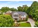 Stately two-story brick home with a covered front porch, well-manicured lawn, and mature trees at 5173 Brendlynn Dr, Suwanee, GA 30024