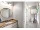 Bright bathroom with shiplap accent wall, granite counters, and round mirror at 5173 Brendlynn Dr, Suwanee, GA 30024