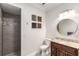 Well-lit bathroom featuring a walk-in shower, granite counters, and a round mirror at 5173 Brendlynn Dr, Suwanee, GA 30024