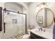 Bathroom featuring a modern shower with glass door and stylish vanity with round mirror and updated fixtures at 5173 Brendlynn Dr, Suwanee, GA 30024