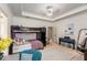 Charming bedroom featuring a bunk bed, piano, large mirror, and tray ceiling at 5173 Brendlynn Dr, Suwanee, GA 30024