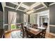 Gray dining room featuring a dark wood table, decorative rug and large windows, offering lots of light at 5173 Brendlynn Dr, Suwanee, GA 30024