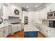 Bright kitchen featuring custom white cabinetry, stainless steel appliances and an island with a marble countertop at 5173 Brendlynn Dr, Suwanee, GA 30024