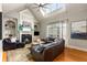 Spacious living room with a fireplace, hardwood floors, and a large window overlooking the yard at 5173 Brendlynn Dr, Suwanee, GA 30024