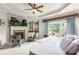 Main bedroom featuring a fireplace, tv, seating area, and bright windows with outdoor views at 5173 Brendlynn Dr, Suwanee, GA 30024