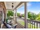 Inviting covered porch with comfortable seating, columns, and scenic neighborhood views at 5173 Brendlynn Dr, Suwanee, GA 30024