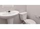 Bathroom featuring a pedestal sink, toilet, and neutral wall color at 139 Palmetto St, Locust Grove, GA 30248