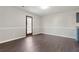Bright living room featuring dark wood floors and door to the backyard at 139 Palmetto St, Locust Grove, GA 30248