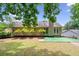 Beautiful backyard with mature trees, green lawn, and patio area for outdoor enjoyment at 2623 Lone Oak Nw Trl, Kennesaw, GA 30144
