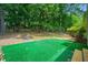 Backyard with green patio area surrounded by landscaping and mature trees at 2623 Lone Oak Nw Trl, Kennesaw, GA 30144