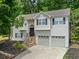 Charming two-story home with stone accents, gray siding, black shutters, and a two-car garage at 2623 Lone Oak Nw Trl, Kennesaw, GA 30144