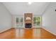 Bright living room featuring a stone fireplace, hardwood floors, a ceiling fan, and French doors to the backyard at 2623 Lone Oak Nw Trl, Kennesaw, GA 30144