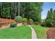 Serene backyard featuring a stone path, well-maintained lawn, and lush landscaping for a peaceful retreat at 107 W Point Trl, Woodstock, GA 30189