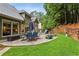 Expansive backyard with paved patio, fire pit, lush lawn and shade trees offer an ideal outdoor retreat at 107 W Point Trl, Woodstock, GA 30189