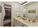 Well-lit bathroom featuring dual sinks, a large mirror, white cabinetry and a separate shower/tub room at 107 W Point Trl, Woodstock, GA 30189