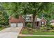 Charming brick home featuring a well-manicured lawn and a two-car garage at 107 W Point Trl, Woodstock, GA 30189