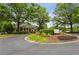 Golf course entrance features a roundabout and well-maintained landscaping with a view of the clubhouse at 107 W Point Trl, Woodstock, GA 30189