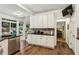 Bright kitchen features white cabinets, granite countertops, stainless steel appliances, and a breakfast nook with backyard view at 107 W Point Trl, Woodstock, GA 30189