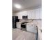 A well-lit kitchen with white cabinets, marble countertops, a stainless steel oven, and a modern black refrigerator at 2499 Peachtree Rd # 506, Atlanta, GA 30305
