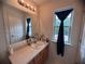 A bathroom features a sink with storage cabinet and a large mirror with vanity lights at 5421 Skylar Creek Ln, Buford, GA 30518