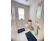 Bathroom boasting a toilet, sink with a round mirror, and blue mats on the tiled floor at 5421 Skylar Creek Ln, Buford, GA 30518