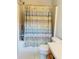 A bathroom features a shower/tub combo with colorful shower curtain and a standard toilet at 5421 Skylar Creek Ln, Buford, GA 30518