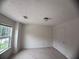 This bedroom boasts a large window that offers natural light and a peaceful view at 5421 Skylar Creek Ln, Buford, GA 30518