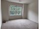 A bright bedroom features neutral carpeting and a double window with green outdoor views at 5421 Skylar Creek Ln, Buford, GA 30518