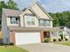 Attractive two-story home with vinyl siding, a two-car garage, and well-maintained landscaping at 5421 Skylar Creek Ln, Buford, GA 30518