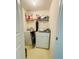 Compact laundry room featuring a washer, dryer, overhead shelf, and neutral-toned walls and flooring at 5421 Skylar Creek Ln, Buford, GA 30518