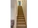 Carpeted stairway with a wooden banister connects the levels of this home at 5421 Skylar Creek Ln, Buford, GA 30518