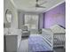 Charming Bedroom with whimsical purple wall, white crib, dresser, and cozy chair near window at 1952 Azalea Dr, Lawrenceville, GA 30043