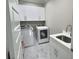 Well-lit laundry room with white cabinets, sink, washer, and dryer at 1952 Azalea Dr, Lawrenceville, GA 30043