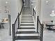 Modern staircase with wooden handrail leads to the upper level near the dining room and kitchen at 1952 Azalea Dr, Lawrenceville, GA 30043